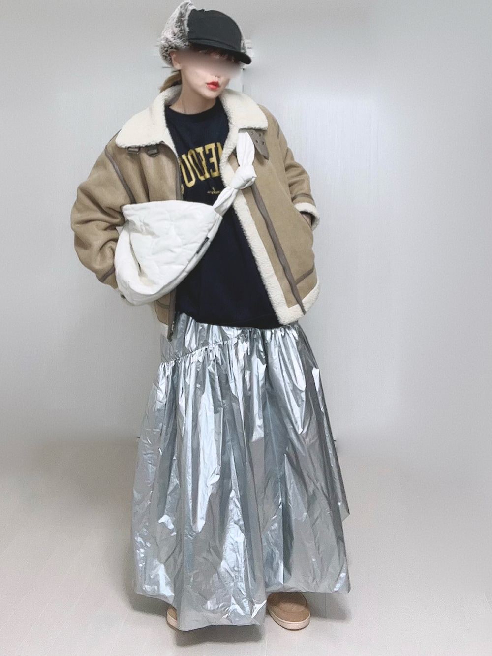 ベージュ系のムートンコート、ホワイト系のショルダーバッグ、シルバー系のスカートを着用したレディースの冬コーディネートの5枚目の写真