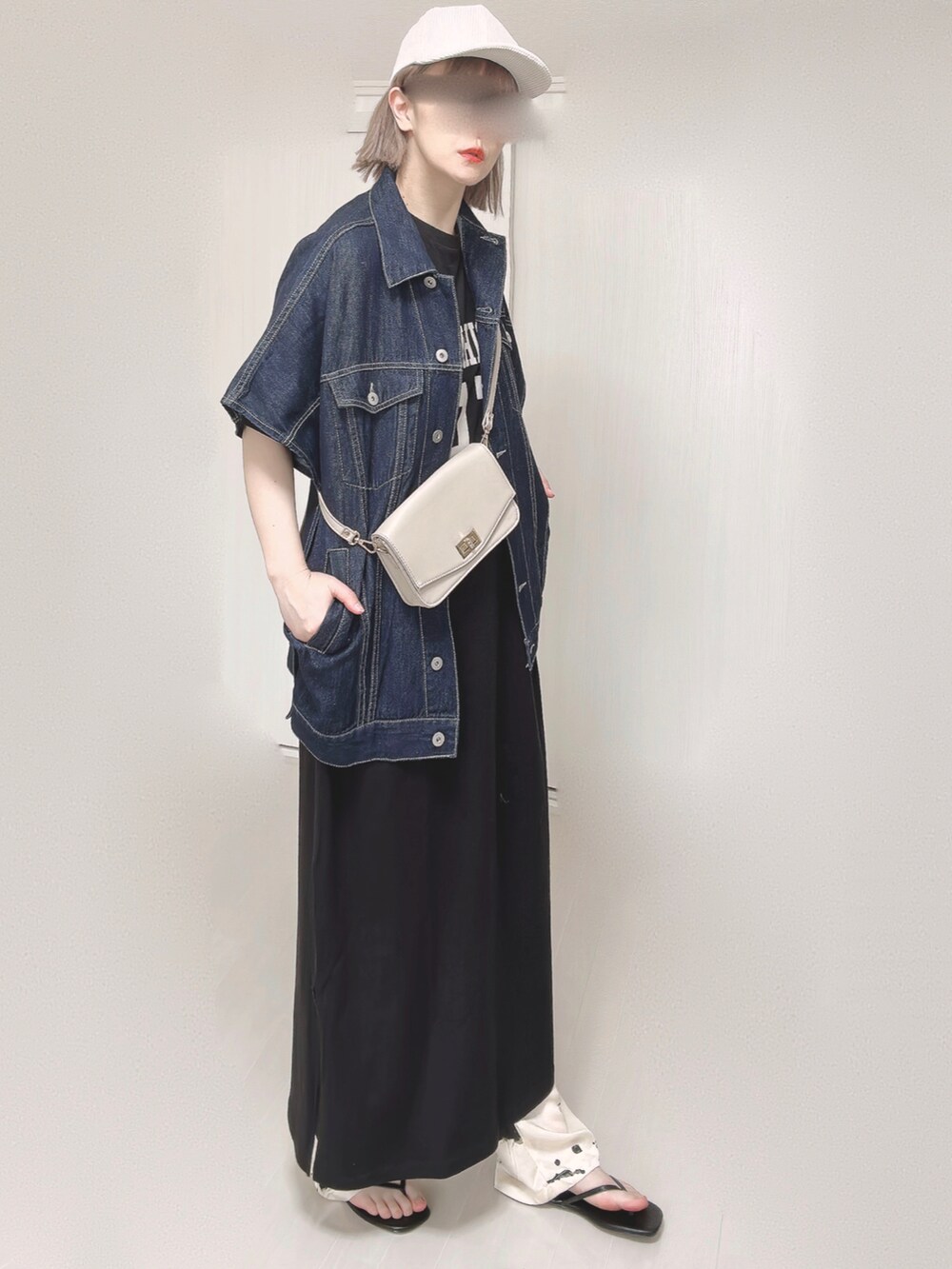 ブルー系のベスト、ベージュ系のショルダーバッグ、ブラック系のサンダルを着用したレディースの春コーディネートの2枚目の写真