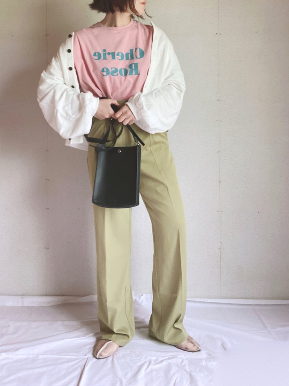 ブラック系のカーディガン/ボレロ、ピンク系のTシャツ/カットソー、グリーン系のスラックスを着用したレディースの夏コーディネートの3枚目の写真