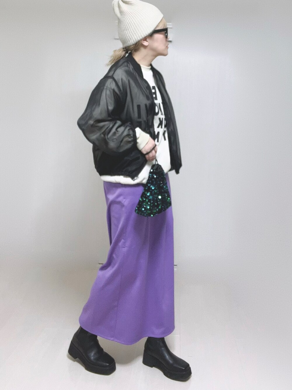 パープル系のスカート、ブラック系のブーツを着用したレディースの冬コーディネートの5枚目の写真