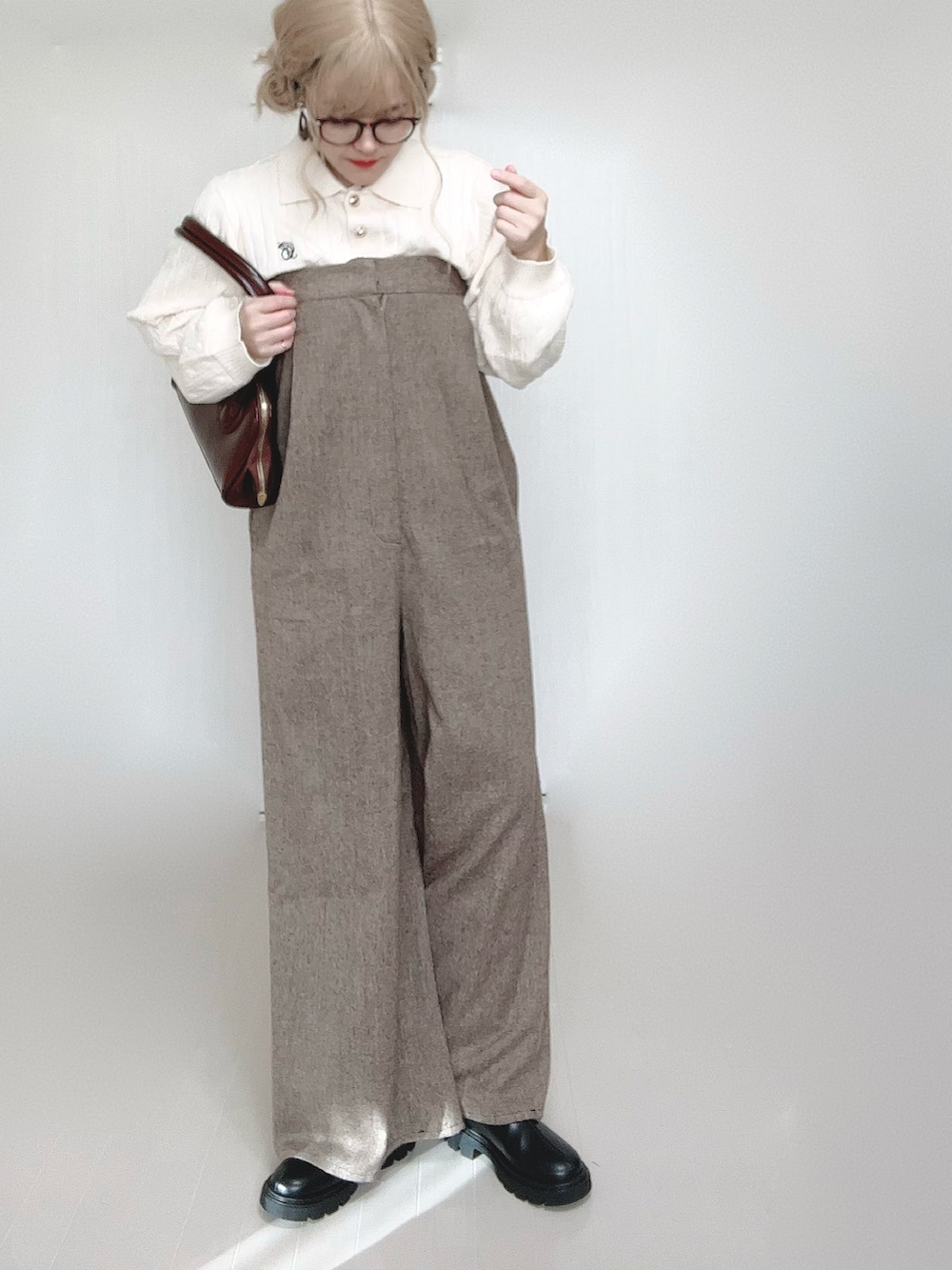 ホワイト系のニット/セーター、ブラウン系のサロペット/オーバーオール、ブラウン系のショルダーバッグを着用したレディースの秋コーディネートの3枚目の写真