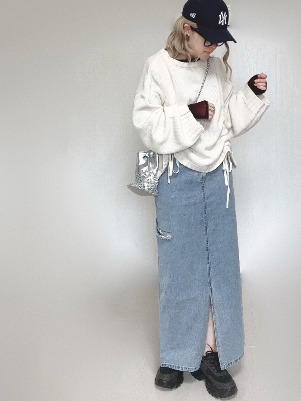 ホワイト系のニット/セーター、ブラウン系のTシャツ/カットソー、シルバー系のショルダーバッグを着用したレディースの冬コーディネートの5枚目の写真