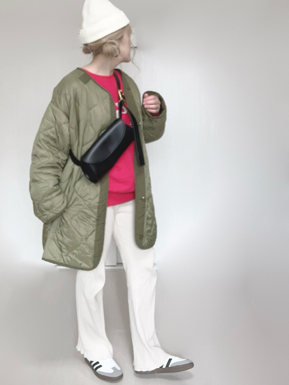 レッド系のスウェット、グリーン系のミリタリージャケット、ホワイト系のその他パンツを着用したレディースの冬コーディネートの2枚目の写真