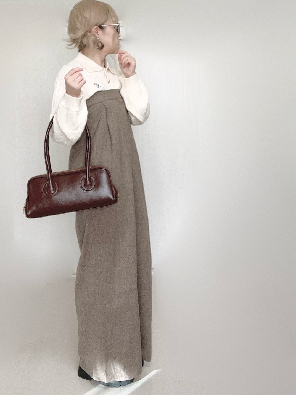 ホワイト系のニット/セーター、ブラウン系のサロペット/オーバーオール、ブラウン系のショルダーバッグを着用したレディースの秋コーディネートの2枚目の写真