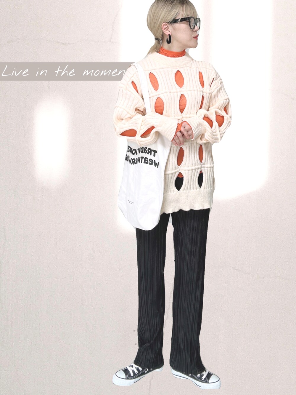 オレンジ系のTシャツ/カットソー、ホワイト系のトートバッグ、ブラック系のその他パンツを着用したレディースの秋コーディネートの4枚目の写真