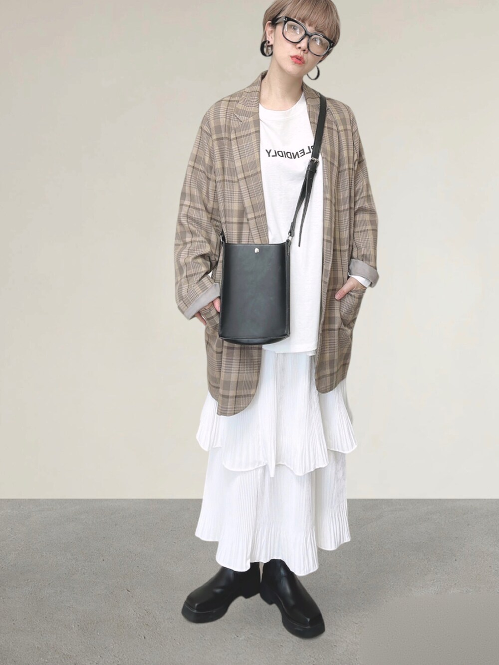 ホワイト系のスカート、ベージュ系のテーラードジャケット、ブラック系のショルダーバッグを着用したレディースの秋コーディネートの4枚目の写真
