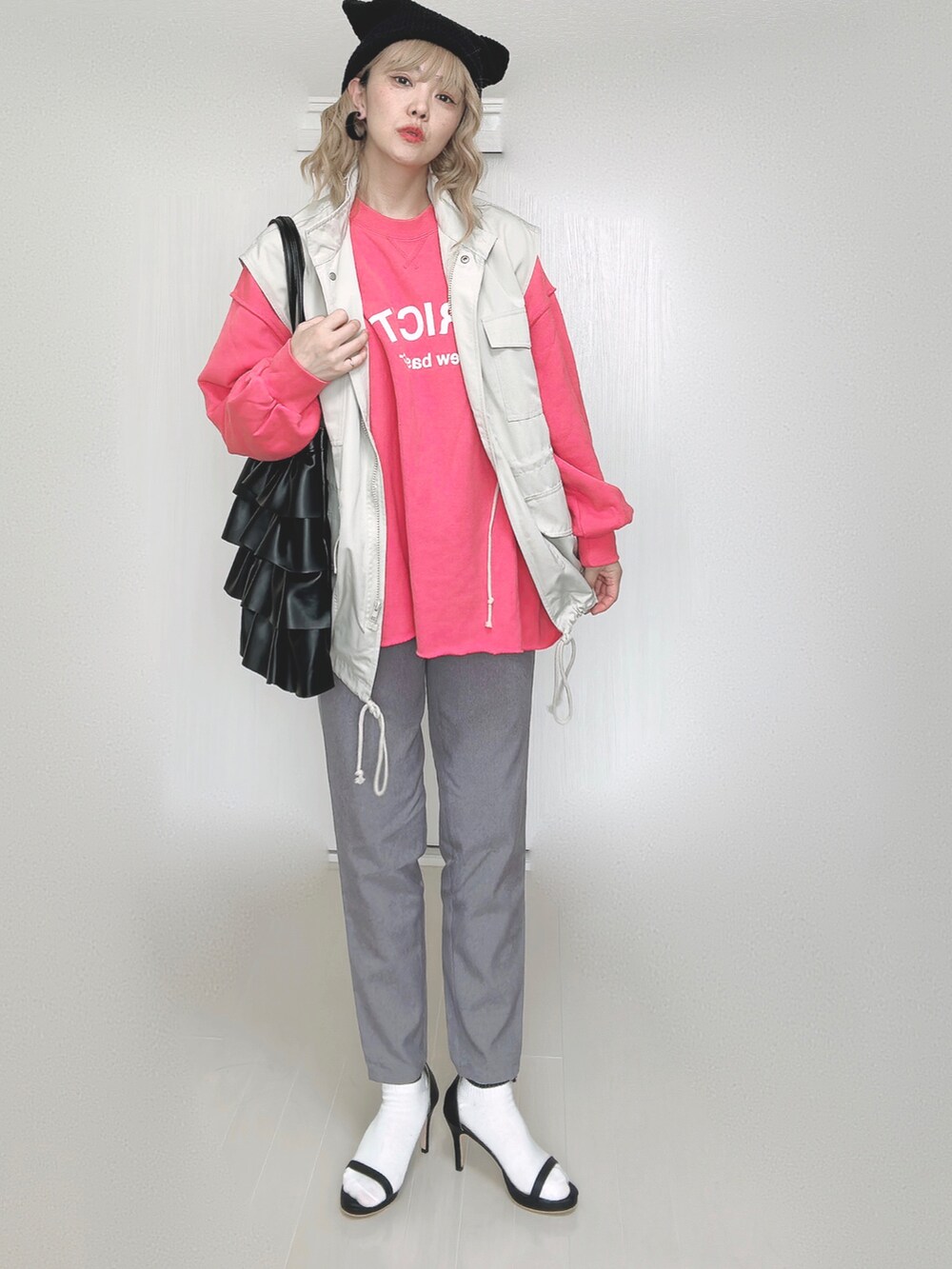 グレー系のその他パンツ、ピンク系のスウェット、ホワイト系のベストを着用したレディースの秋コーディネートの3枚目の写真