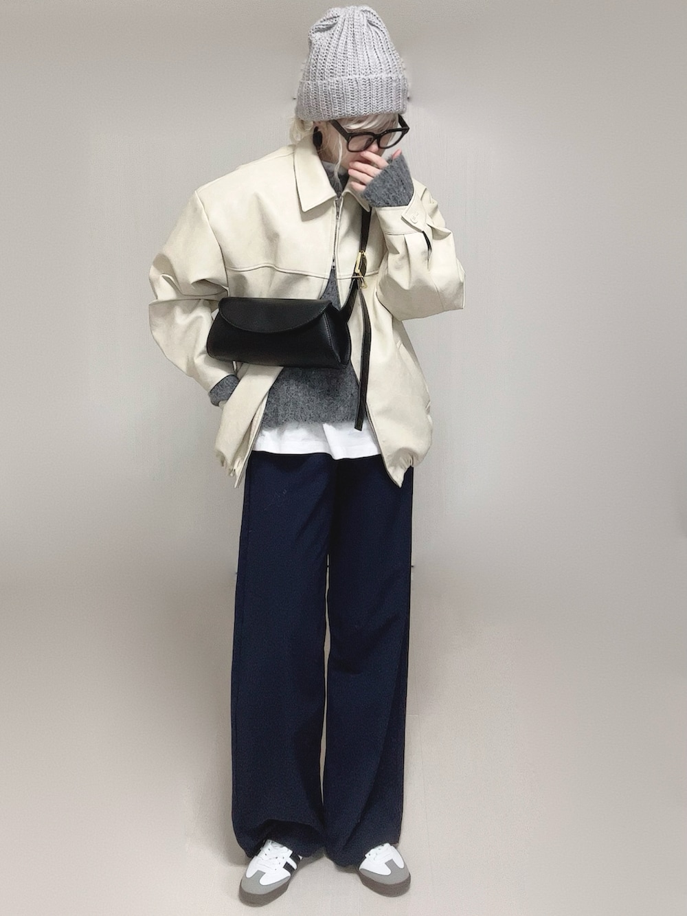 ホワイト系のブルゾン、ホワイト系のTシャツ/カットソー、ブラック系のスラックスを着用したレディースの冬コーディネートの4枚目の写真