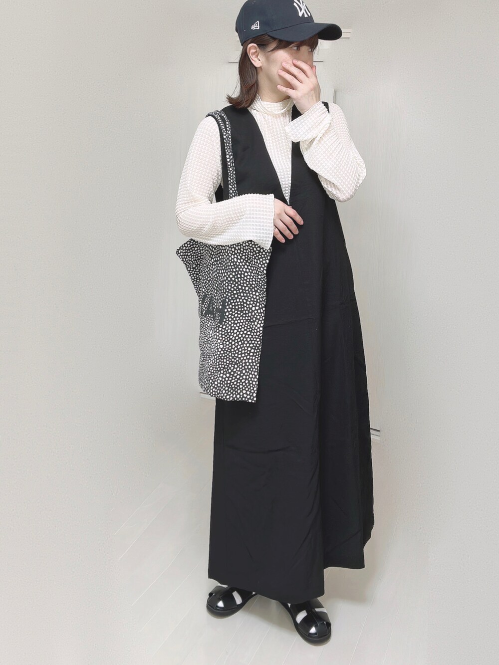 ホワイト系のTシャツ/カットソー、ブラック系のワンピース、ブラック系のサンダルを着用したレディースの春コーディネートの3枚目の写真