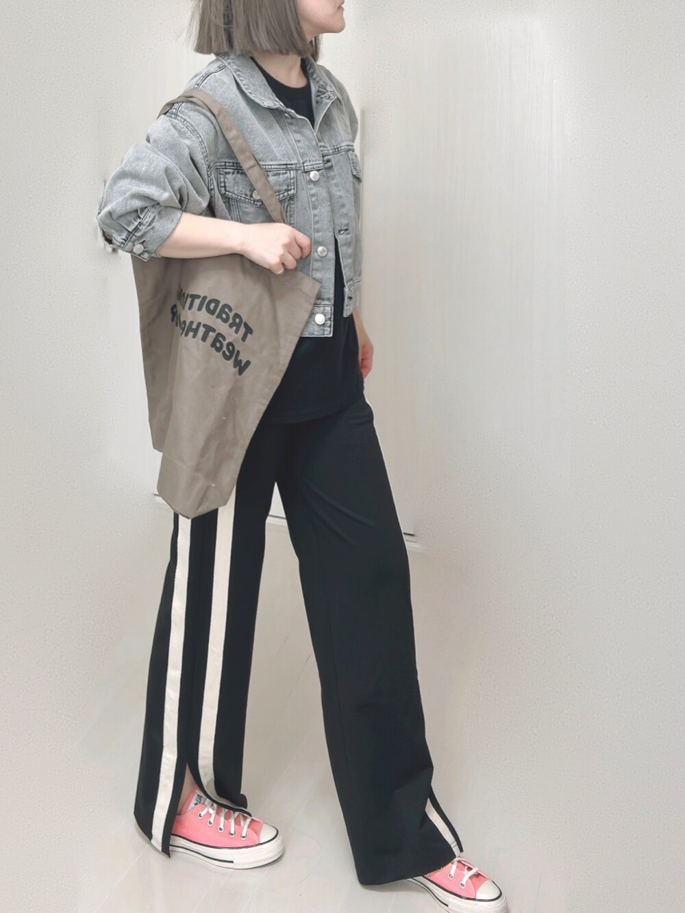 ブラック系のTシャツ/カットソー、ブラック系のデニムジャケット、ブラウン系のトートバッグを着用したレディースの秋コーディネートの5枚目の写真