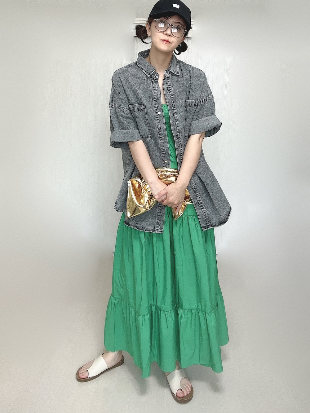 ブラック系のシャツ/ブラウス、ゴールド系のショルダーバッグ、ホワイト系のサンダルを着用したレディースの夏コーディネートの2枚目の写真