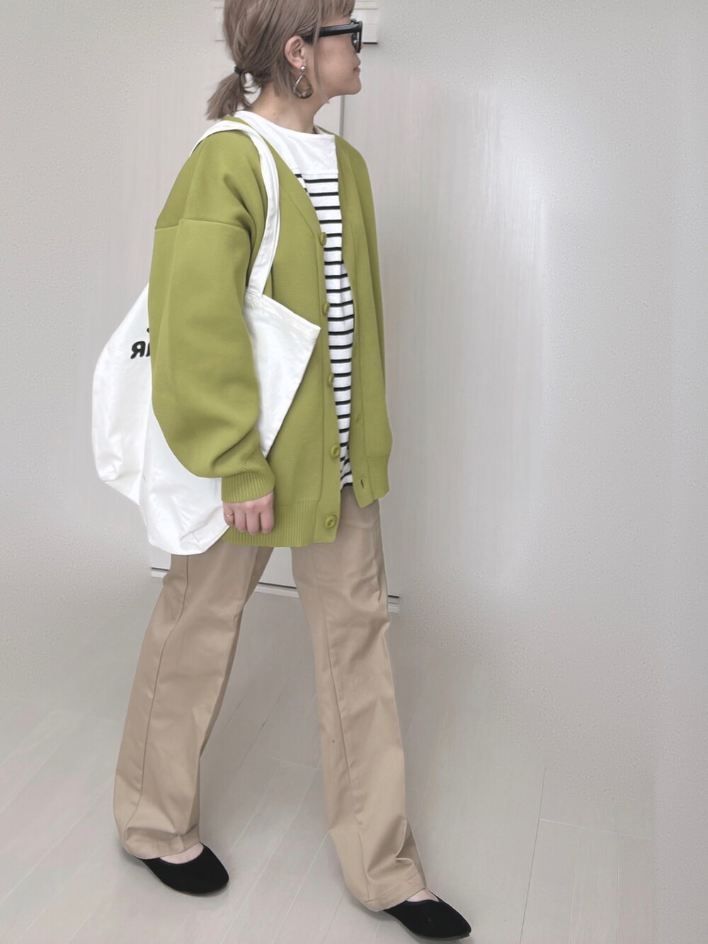 ベージュ系のチノパンツ、グリーン系のカーディガン/ボレロ、ブラック系のTシャツ/カットソーを着用したレディースの冬コーディネートの3枚目の写真