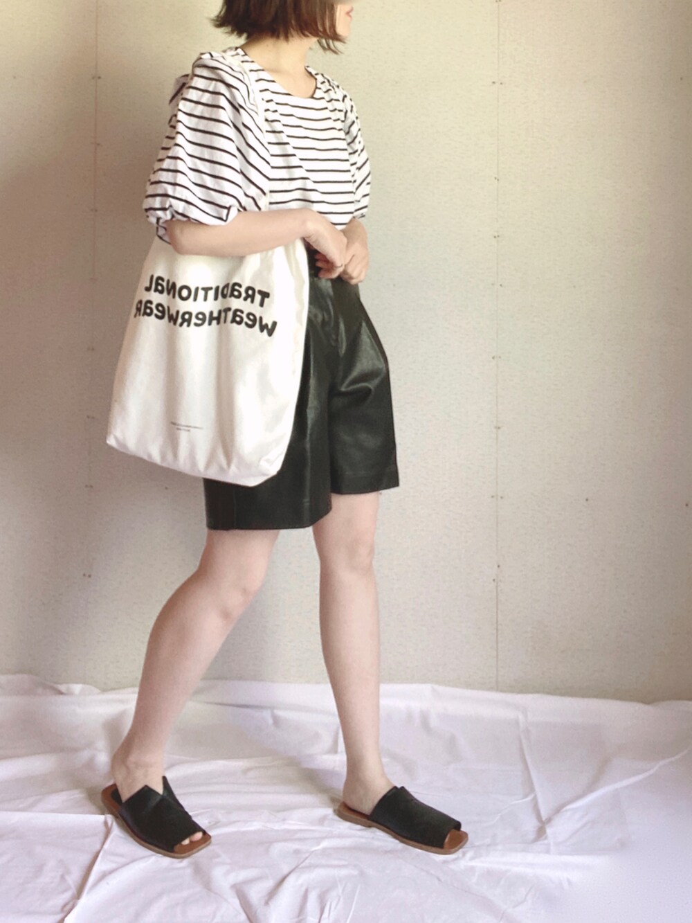 ブラック系のTシャツ/カットソー、ブラック系のその他パンツ、ホワイト系のトートバッグを着用したレディースの夏コーディネートの4枚目の写真