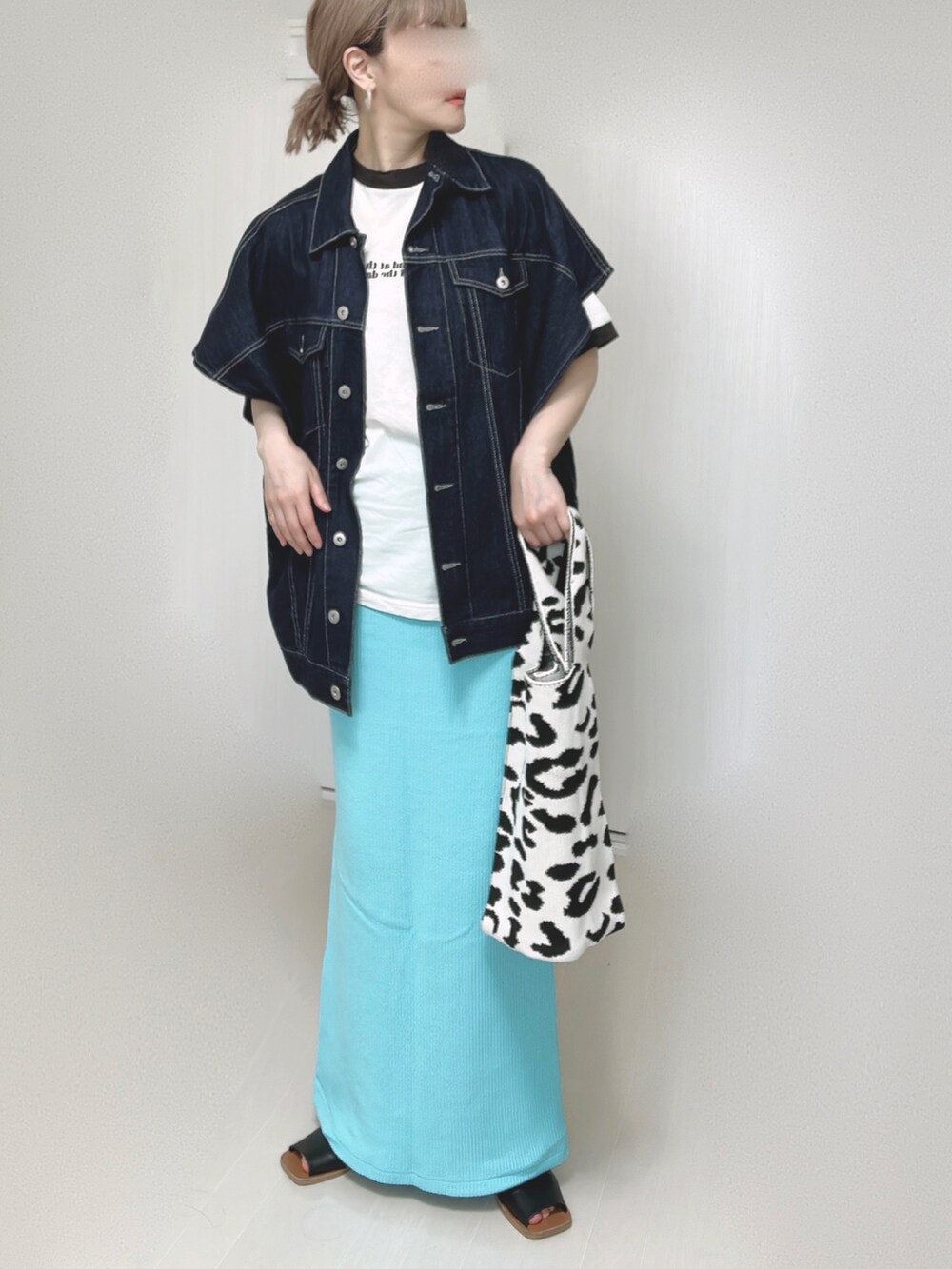 ブルー系のベスト、ブルー系のスカート、ブラック系のサンダルを着用したレディースの春コーディネートの4枚目の写真