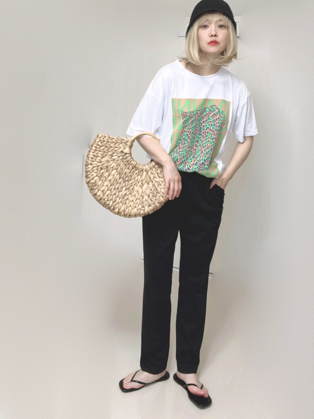 ベージュ系のかごバッグ、ブラック系のサンダルを着用したレディースの夏コーディネートの4枚目の写真