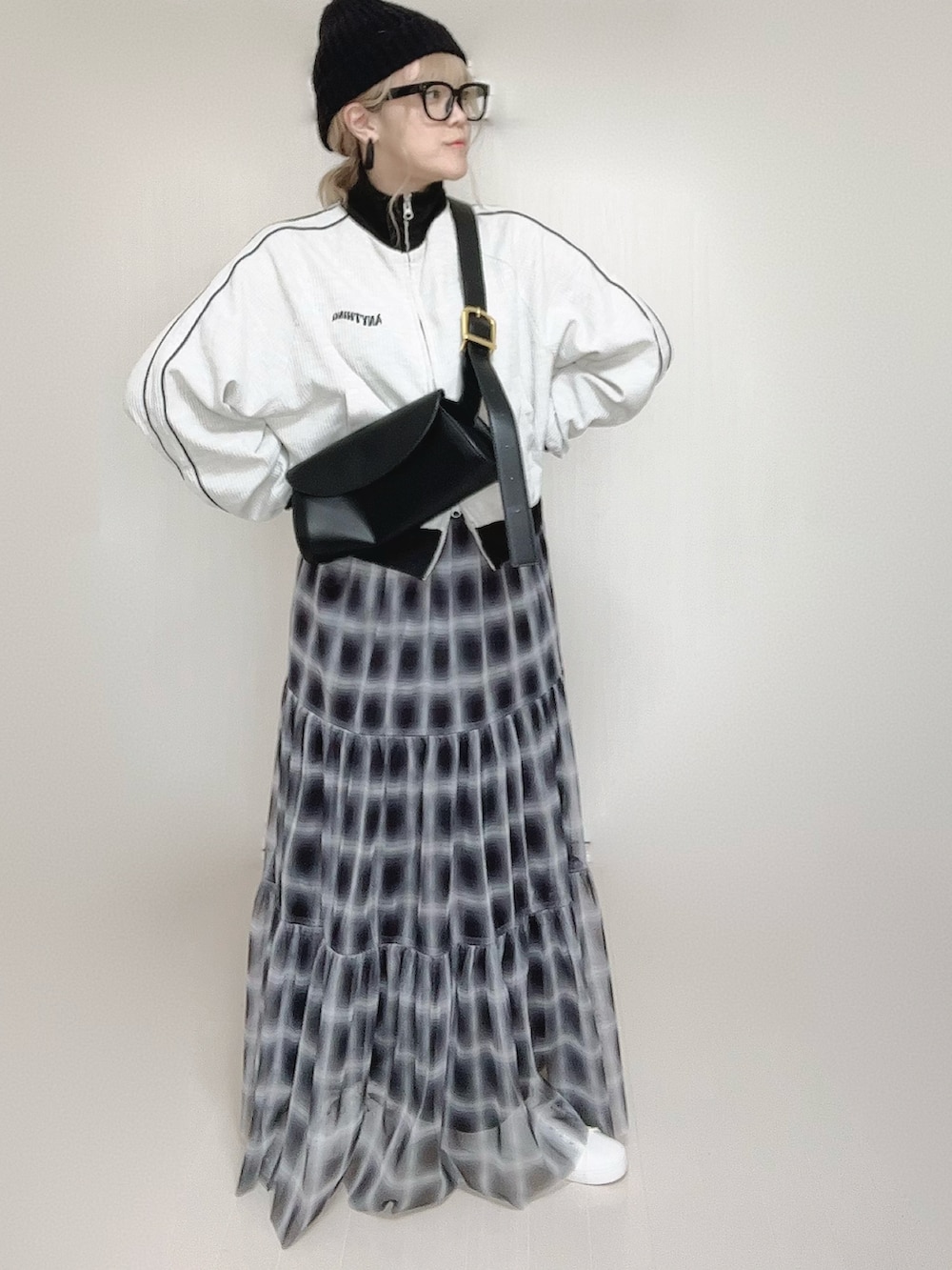 ブラック系のスカート、ベージュ系のジャージ、ホワイト系のスニーカーを着用したレディースの秋コーディネートの4枚目の写真