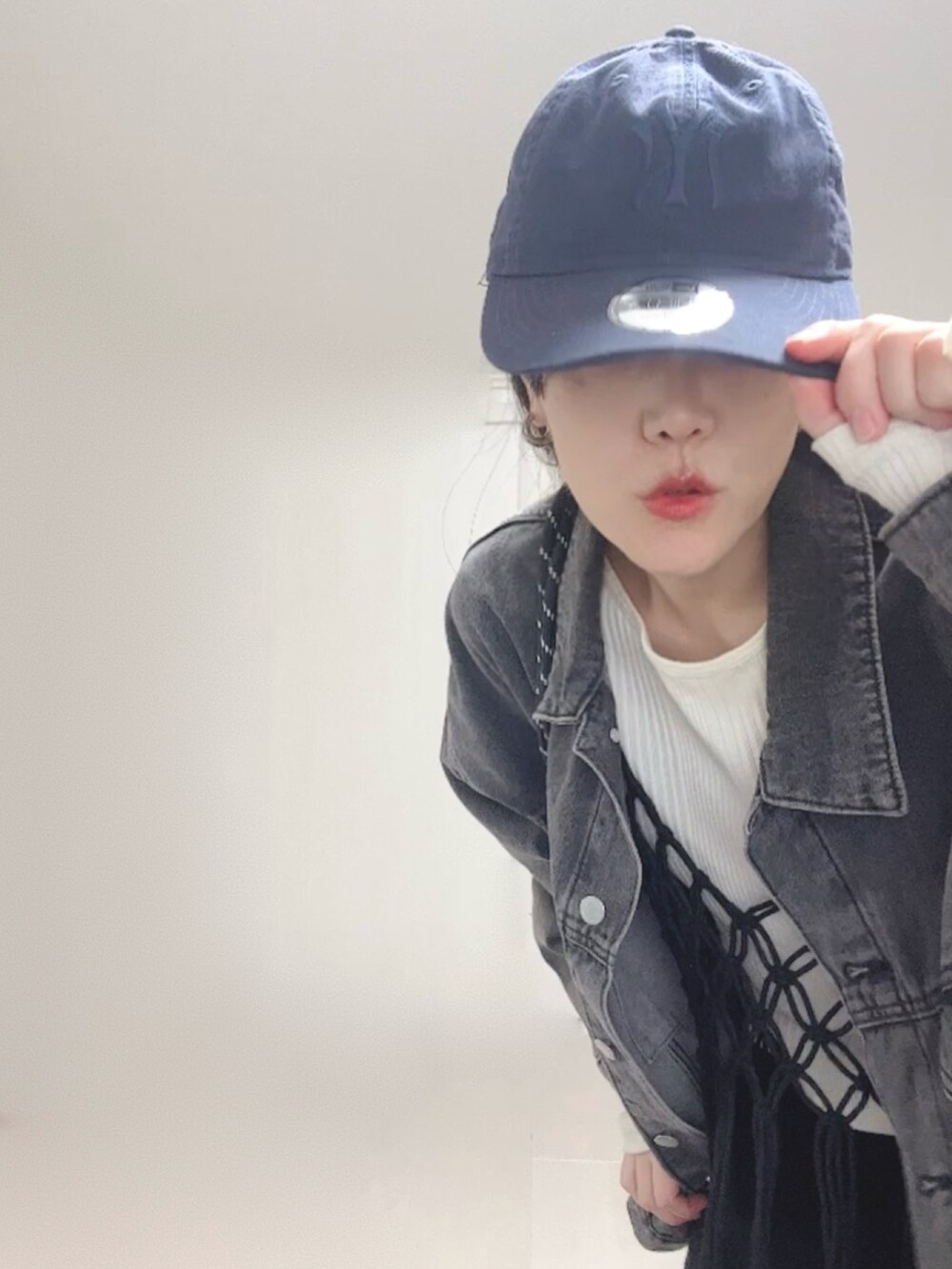 ベージュ系のTシャツ/カットソー、ブラック系のベスト、ブラック系のデニムジャケットを着用したレディースの秋コーディネートの3枚目の写真