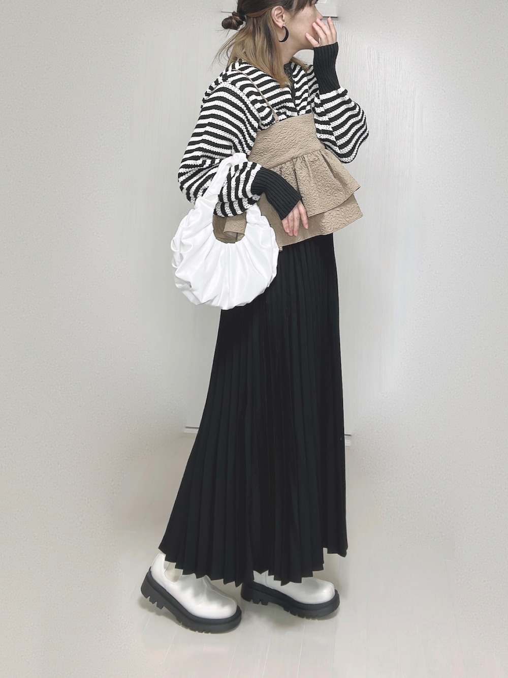 ホワイト系のカーディガン/ボレロ、ベージュ系のキャミソール、ブラック系のスカートを着用したレディースの秋コーディネートの4枚目の写真