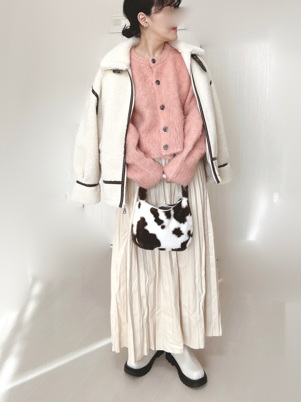 ピンク系のカーディガン/ボレロ、ホワイト系のブルゾン、ホワイト系のスカートを着用したレディースの冬コーディネートの2枚目の写真