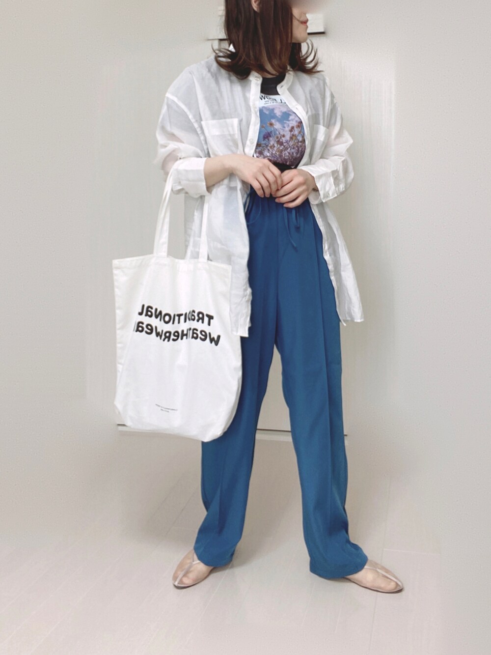 ブルー系のその他パンツ、ホワイト系のシャツ/ブラウス、ホワイト系のトートバッグを着用したレディースの春コーディネートの2枚目の写真