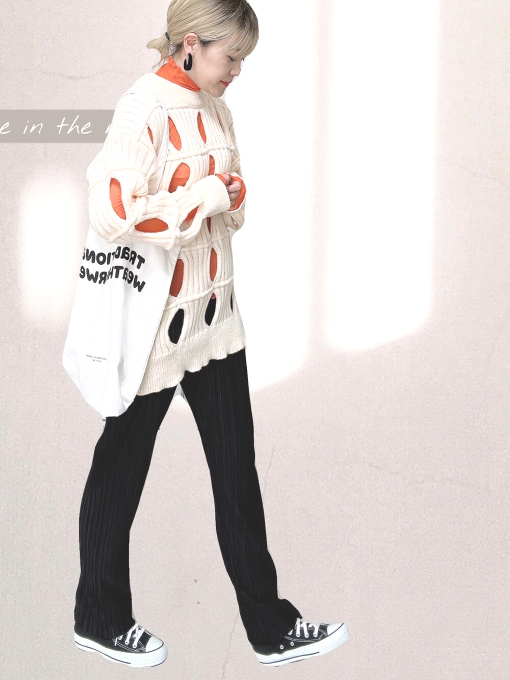 オレンジ系のTシャツ/カットソー、ホワイト系のトートバッグ、ブラック系のその他パンツを着用したレディースの秋コーディネートの2枚目の写真