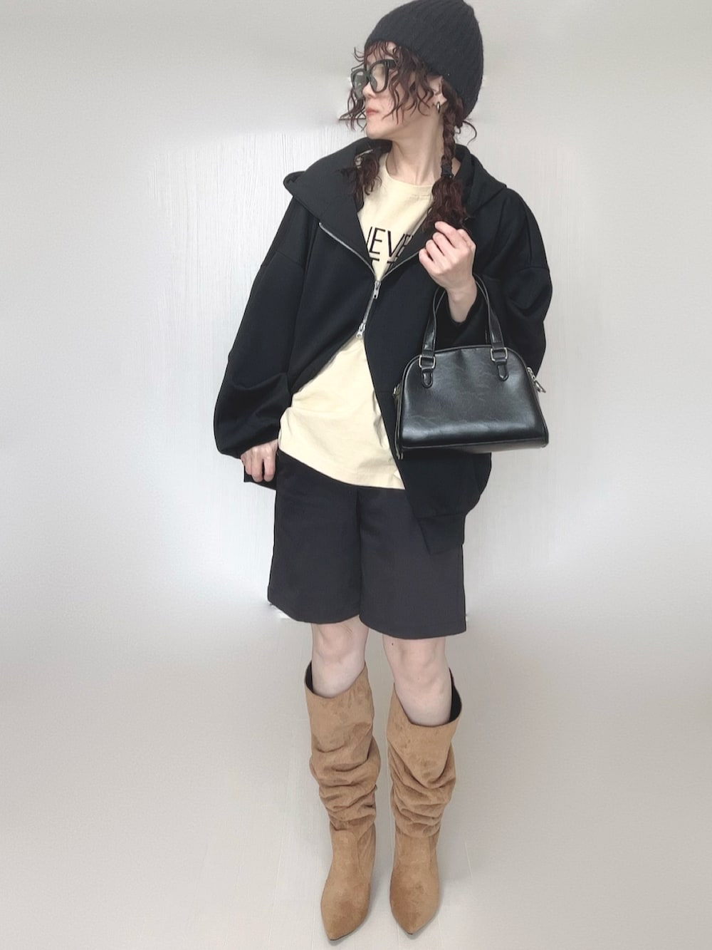 ブラック系のパーカー、ブラック系のボストンバッグ、ベージュ系のTシャツ/カットソーを着用したレディースの冬コーディネートの4枚目の写真