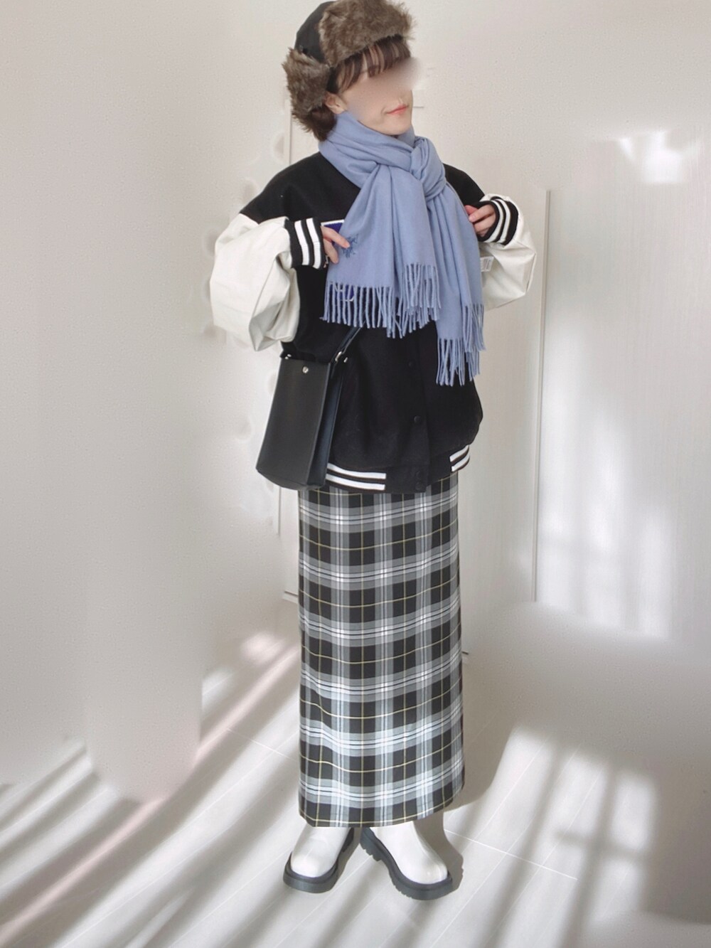 ブラック系のスタジャン、ブラック系のスカート、ブラック系のショルダーバッグを着用したレディースの冬コーディネートの2枚目の写真