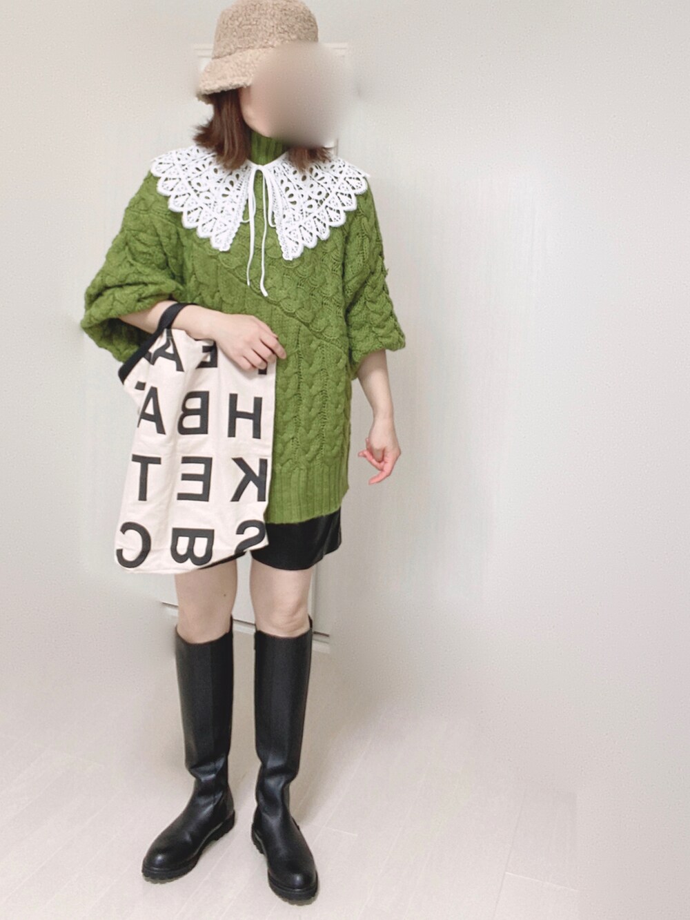 ブラック系のブーツ、グリーン系のニット/セーター、ホワイト系のトートバッグを着用したレディースの秋コーディネートの2枚目の写真