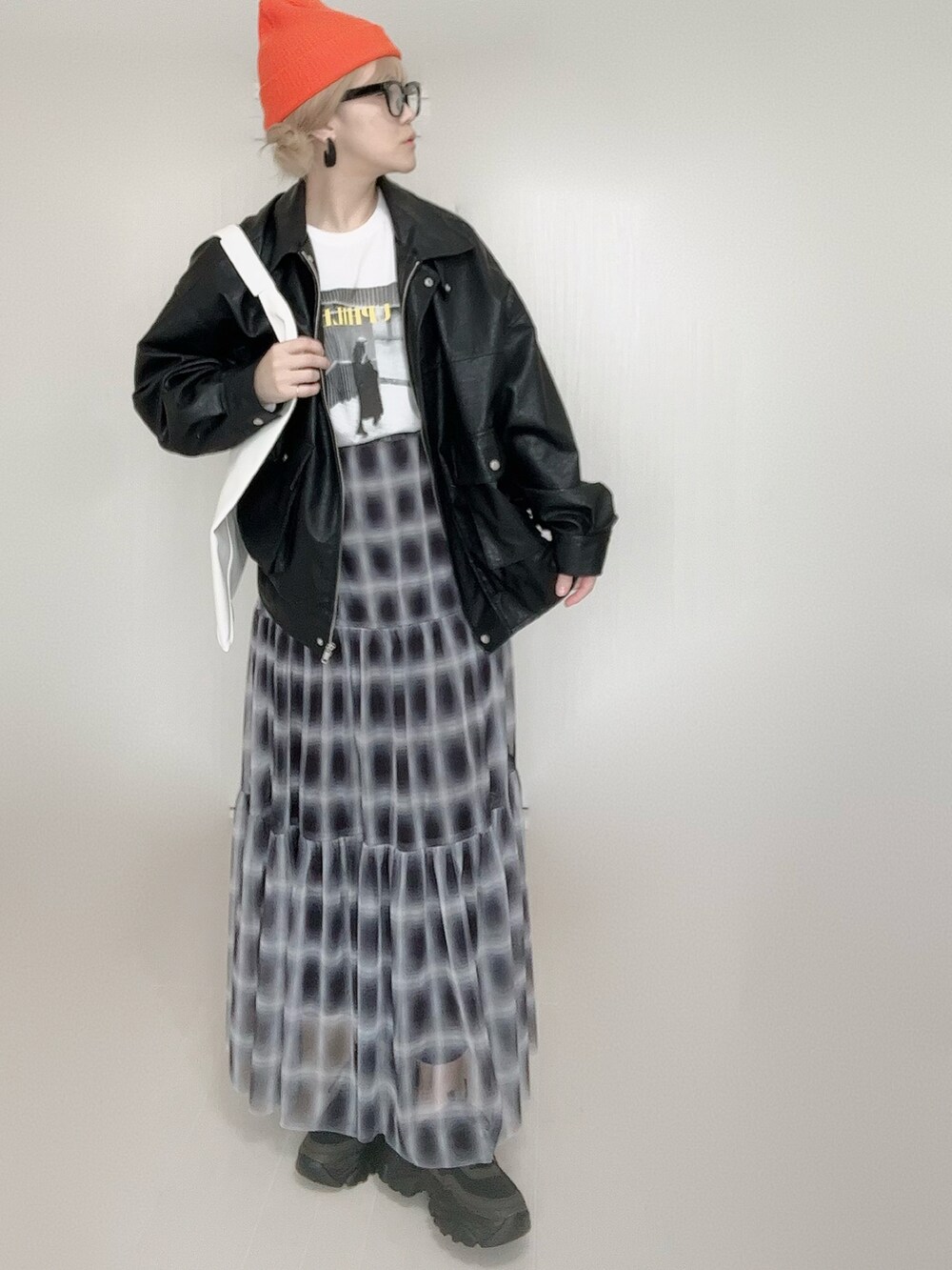 ブラック系のスカート、ブラック系のブルゾン、ホワイト系のTシャツ/カットソーを着用したレディースの秋コーディネートの3枚目の写真