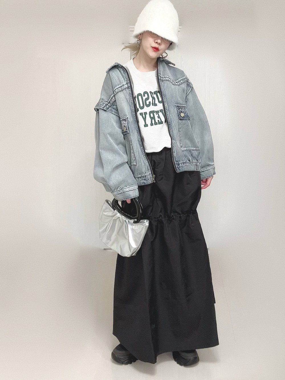 ブルー系のブルゾン、ブラック系のスカート、ブラック系のスニーカーを着用したレディースの春コーディネートの2枚目の写真