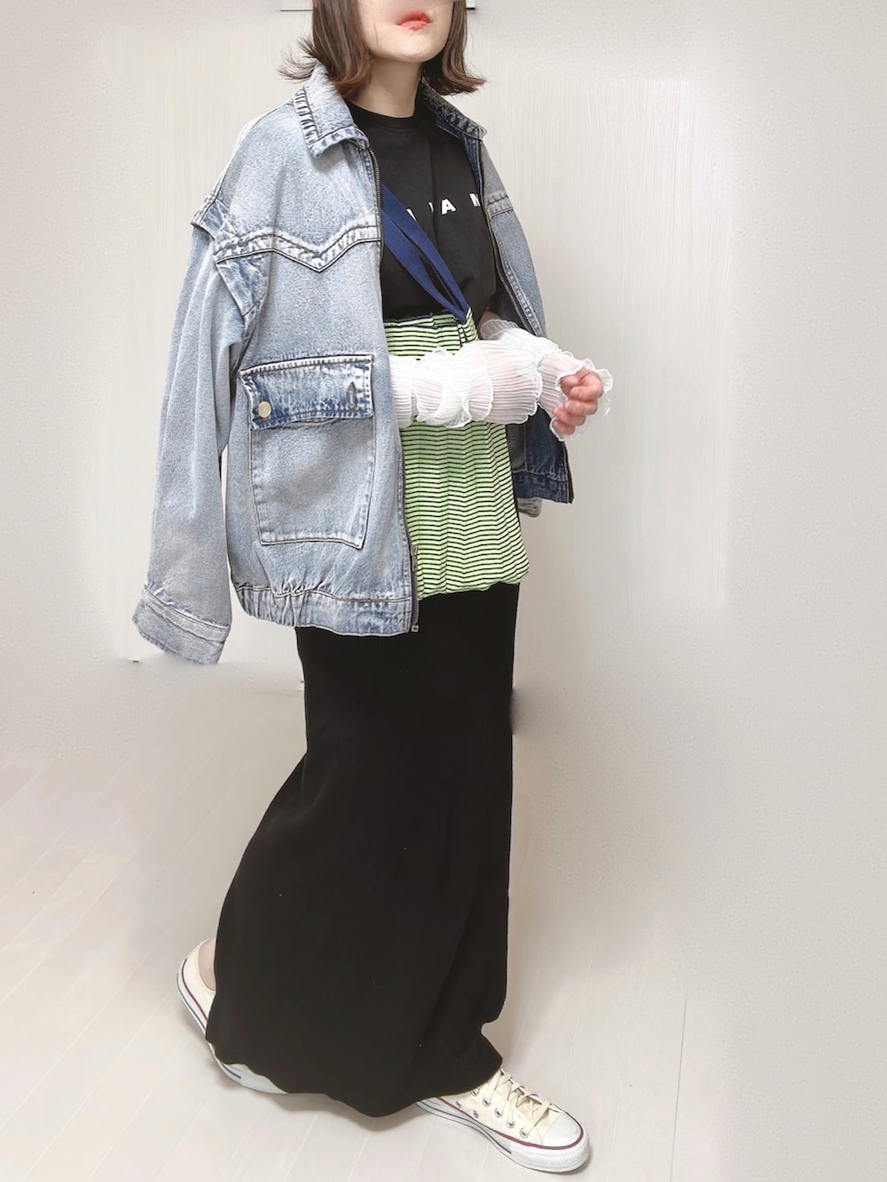 ブルー系のブルゾン、ブラック系のTシャツ/カットソー、グリーン系のトートバッグを着用したレディースの春コーディネートの3枚目の写真