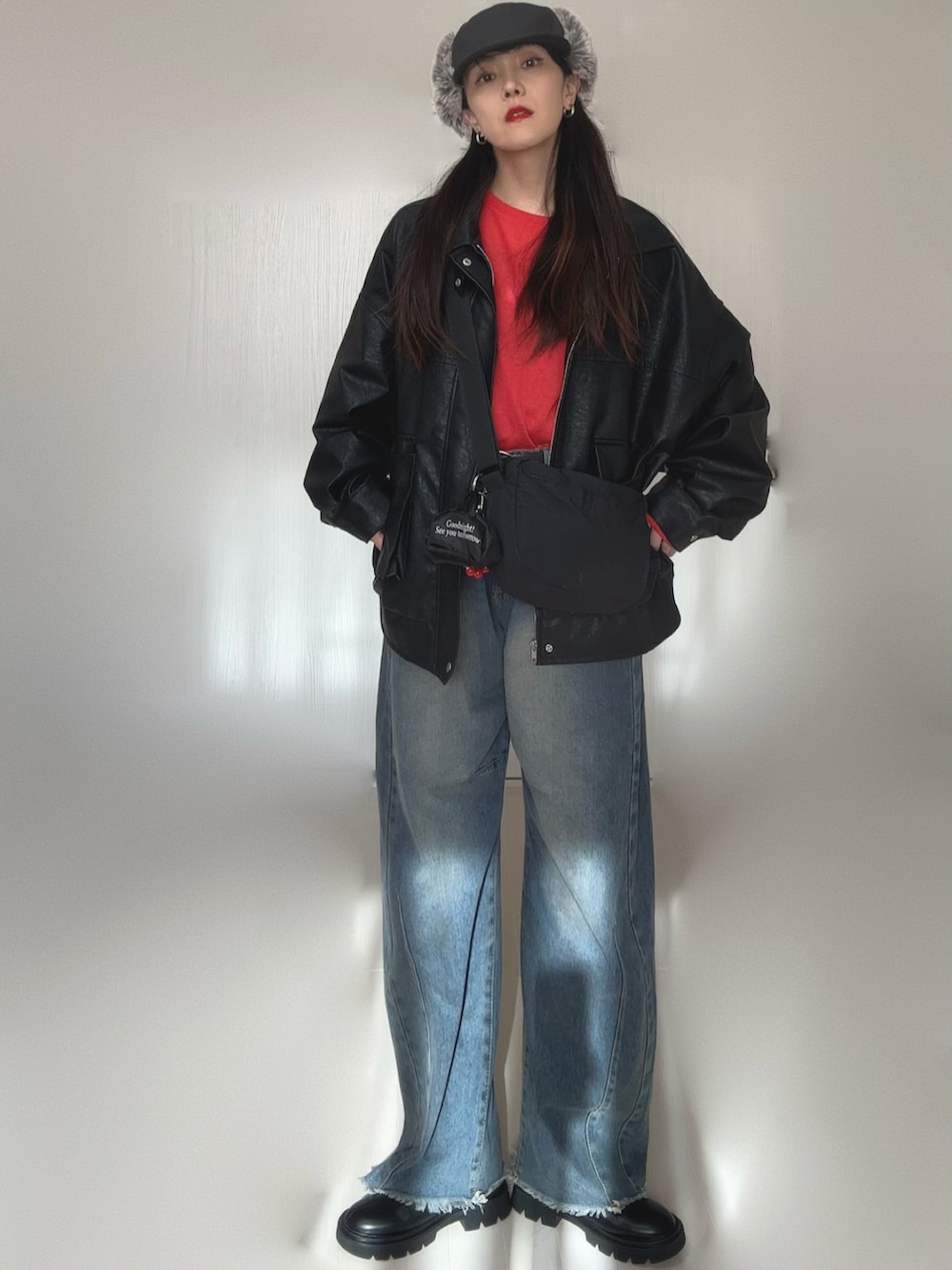 ブラック系のブルゾン、レッド系のTシャツ/カットソー、ブラック系のブーツを着用したレディースの冬コーディネートの5枚目の写真