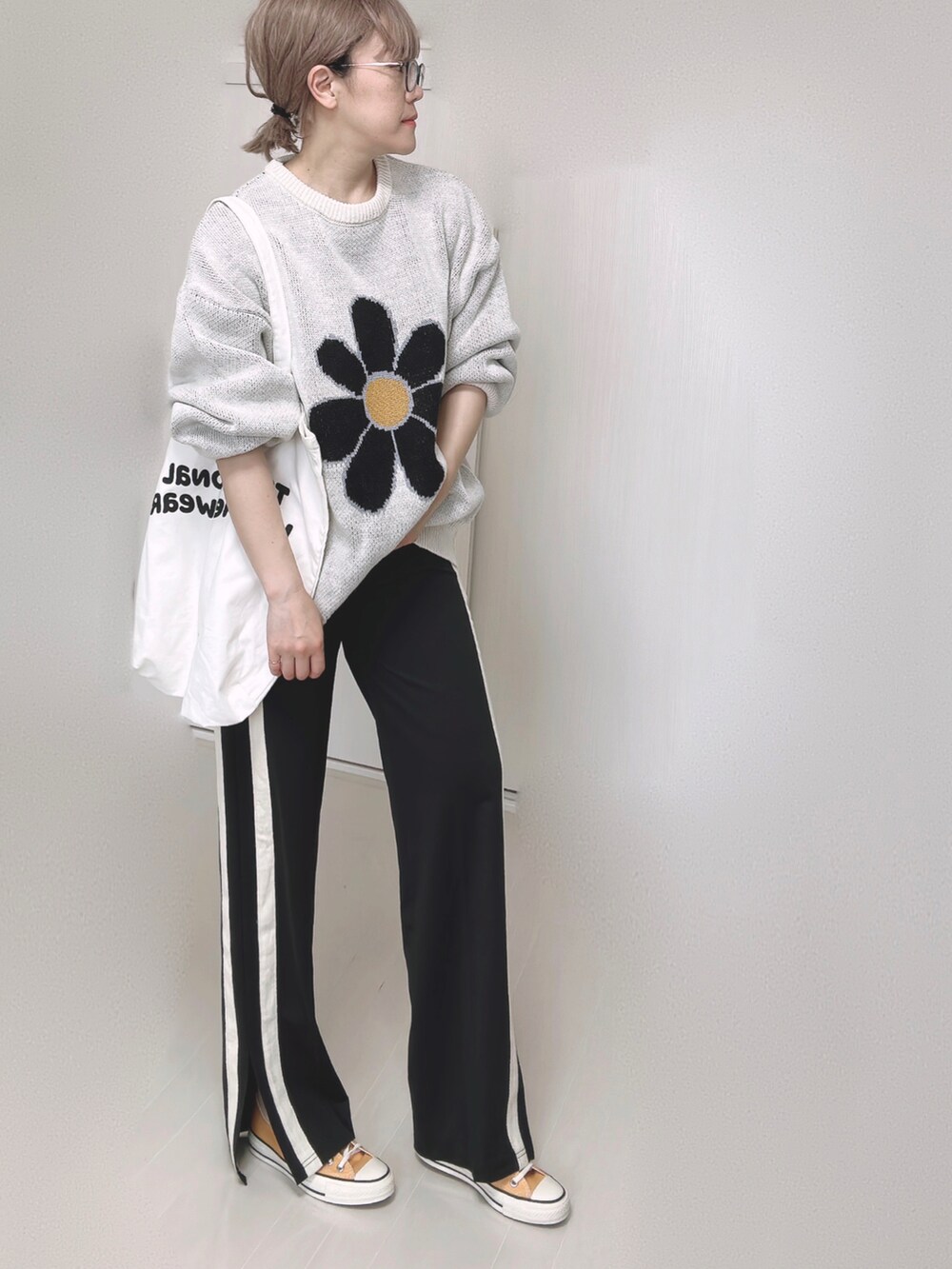 ホワイト系のニット/セーター、ブラック系のその他パンツ、ホワイト系のトートバッグを着用したレディースの夏コーディネートの2枚目の写真