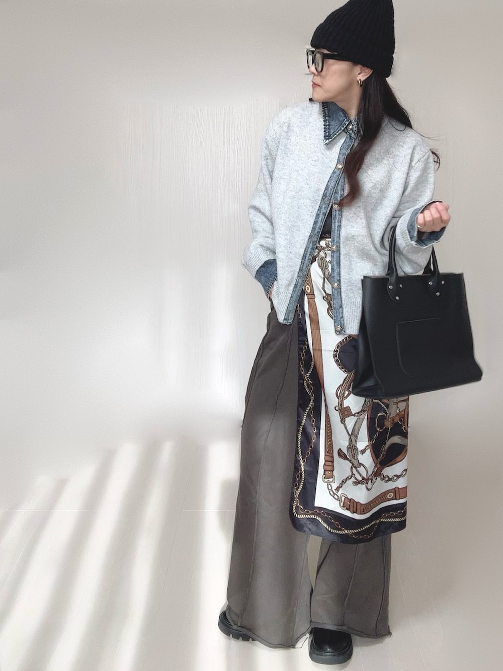 ブラック系のブーツ、ベージュ系のカーディガン/ボレロ、ブラック系のスウェットパンツを着用したレディースの冬コーディネートの4枚目の写真