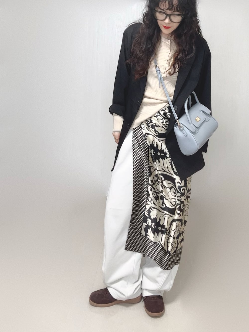 ブラック系のテーラードジャケット、ホワイト系のニット/セーター、その他のバンダナ/スカーフを着用したレディースの春コーディネートの4枚目の写真