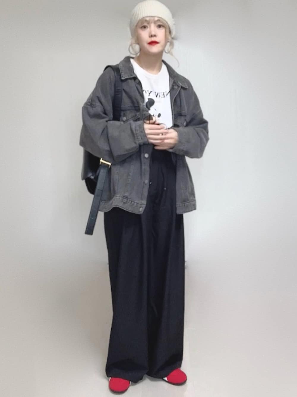 ブラック系のデニムジャケット、ブラック系のスラックス、ホワイト系のTシャツ/カットソーを着用したレディースの冬コーディネートの5枚目の写真