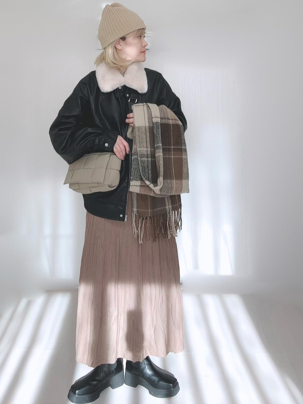 ブラック系のブルゾン、ブラウン系のスカート、ブラック系のブーツを着用したレディースの冬コーディネートの3枚目の写真