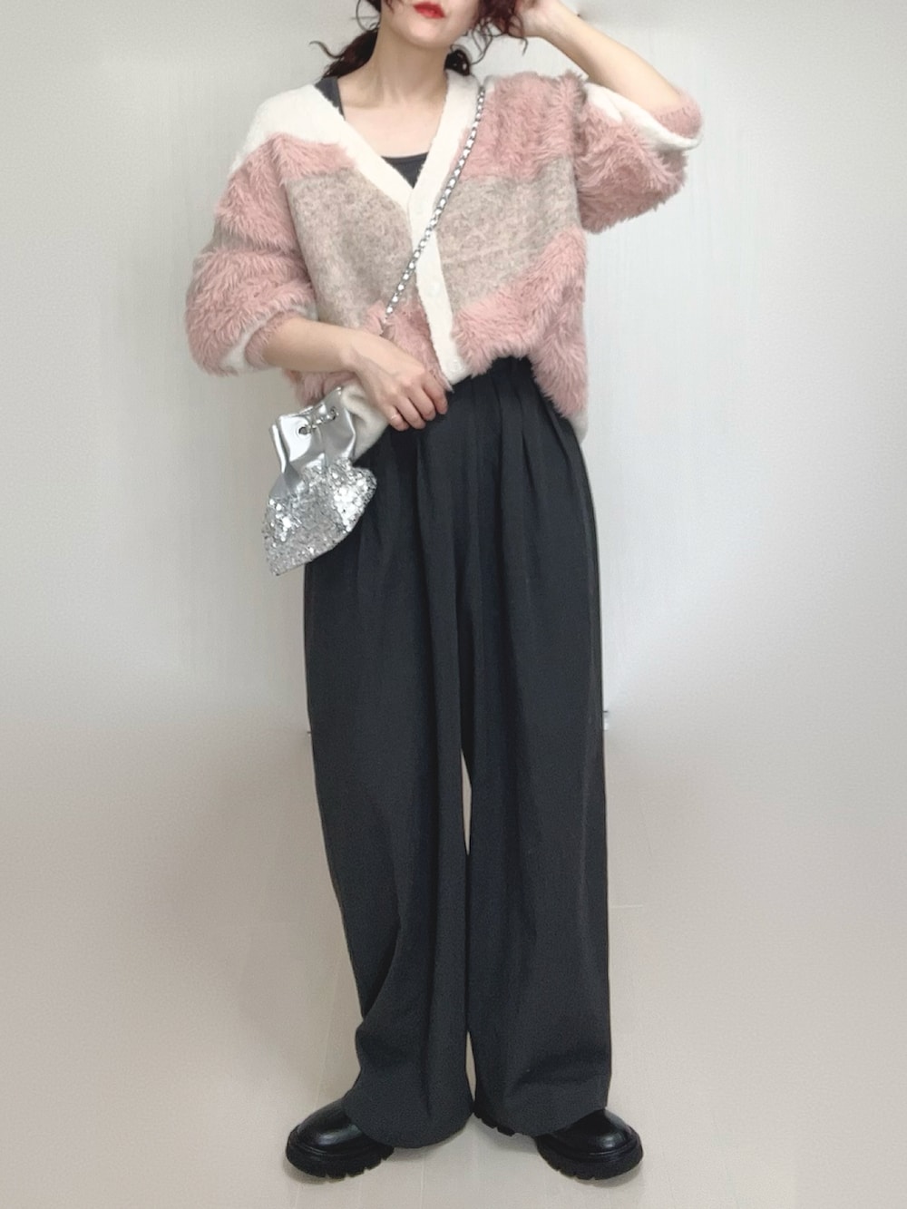 ホワイト系のカーディガン/ボレロ、ブラック系のブーツ、シルバー系のショルダーバッグを着用したレディースの秋コーディネートの2枚目の写真