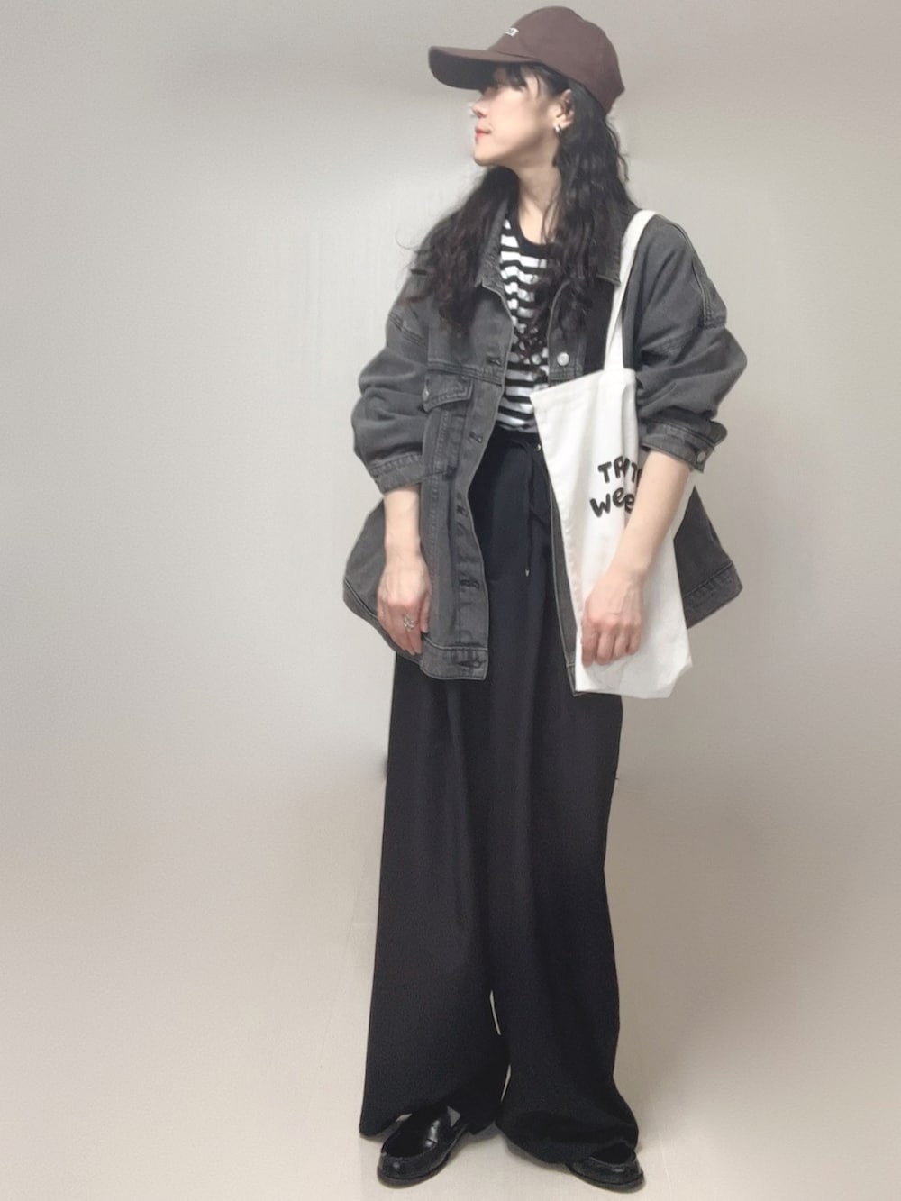 ブラック系のデニムジャケット、ブラック系のスラックス、ホワイト系のTシャツ/カットソーを着用したレディースの春コーディネートの3枚目の写真