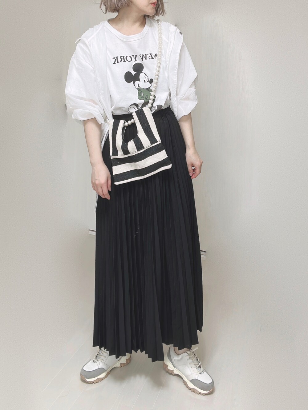 ホワイト系のTシャツ/カットソー、ホワイト系のショルダーバッグ、ブラック系のスカートを着用したレディースの春コーディネートの4枚目の写真