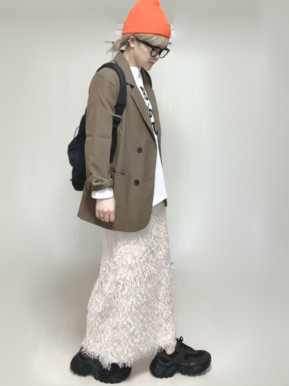 ホワイト系のTシャツ/カットソー、ブラウン系のテーラードジャケット、ブラック系のスニーカーを着用したレディースの春コーディネートの3枚目の写真