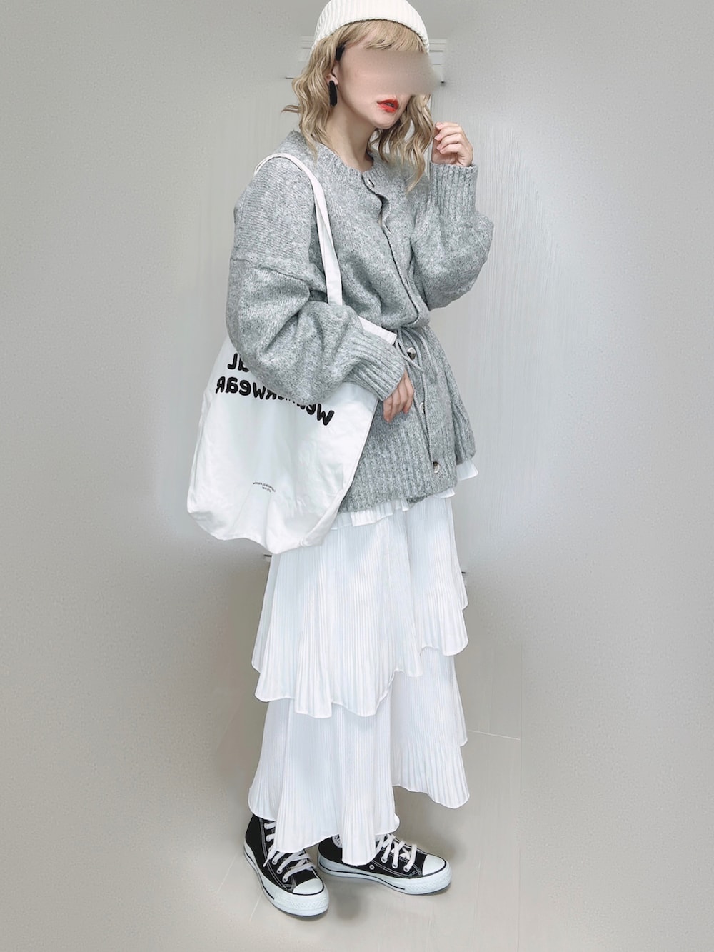 ホワイト系のスカート、ホワイト系のトートバッグ、ブラック系のスニーカーを着用したレディースの秋コーディネートの5枚目の写真