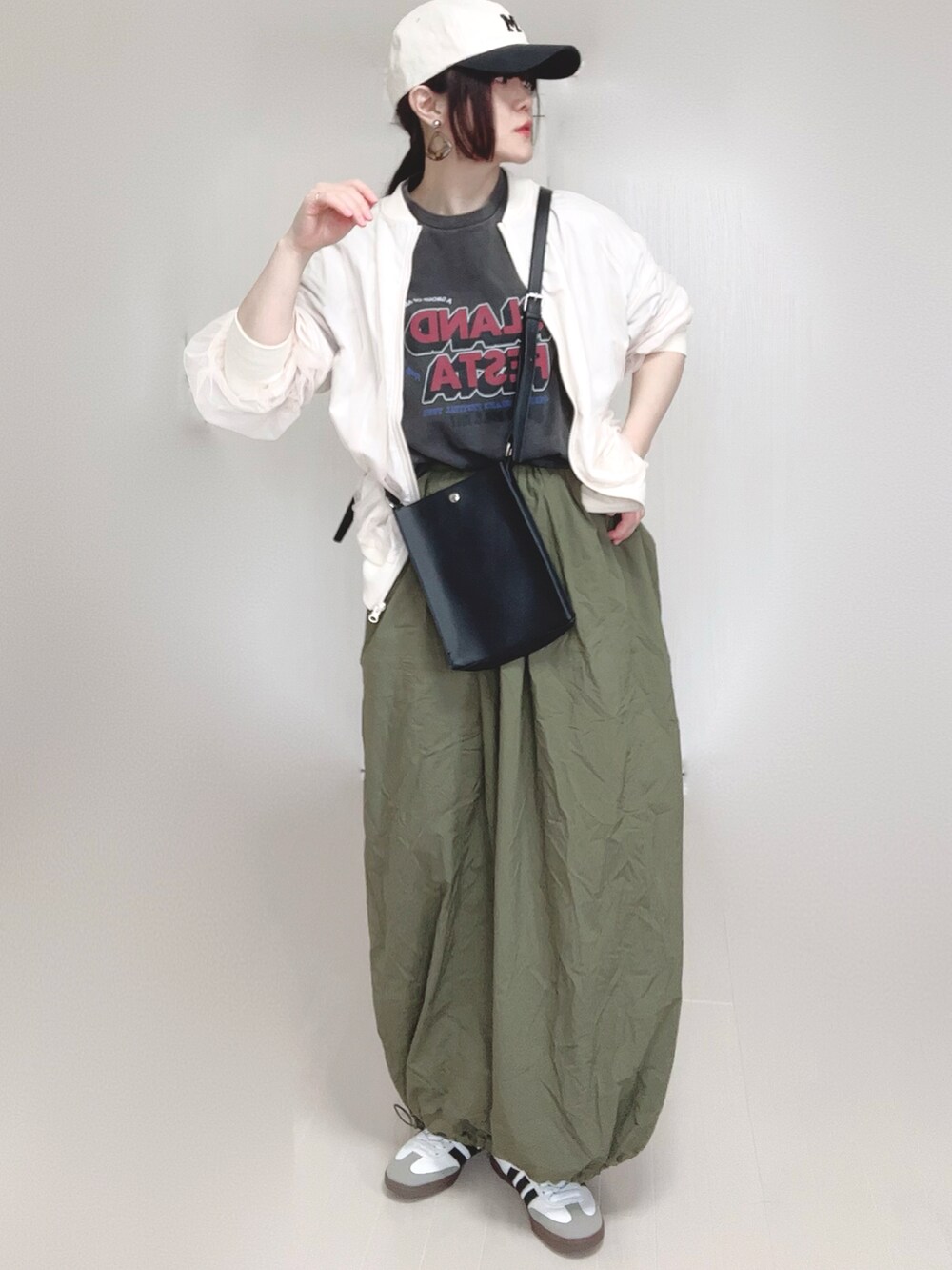 ホワイト系のブルゾン、グレー系のTシャツ/カットソー、ブラック系のショルダーバッグを着用したレディースの春コーディネートの4枚目の写真