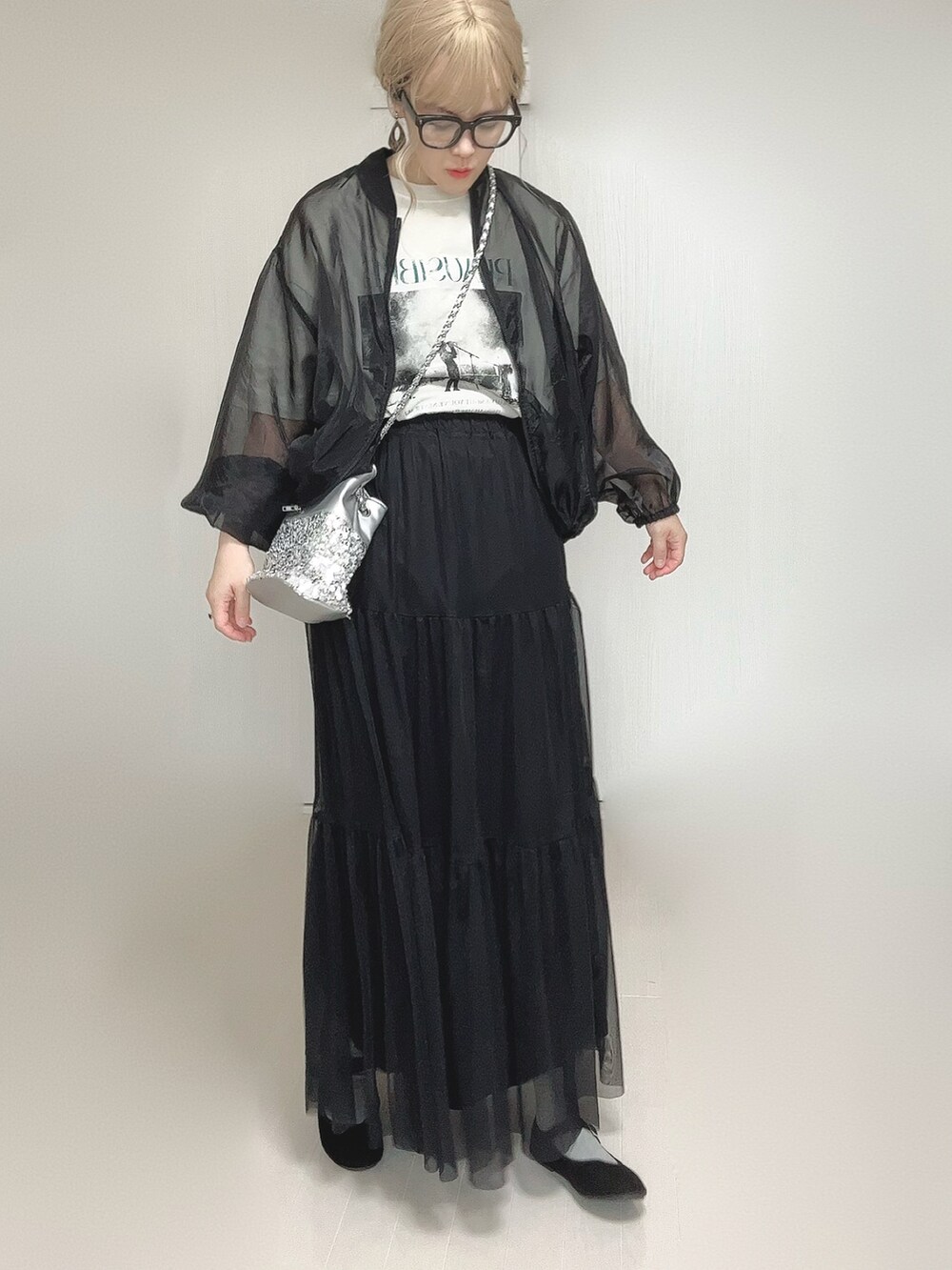 ブラック系のスカート、ホワイト系のTシャツ/カットソー、シルバー系のショルダーバッグを着用したレディースの秋コーディネートの3枚目の写真