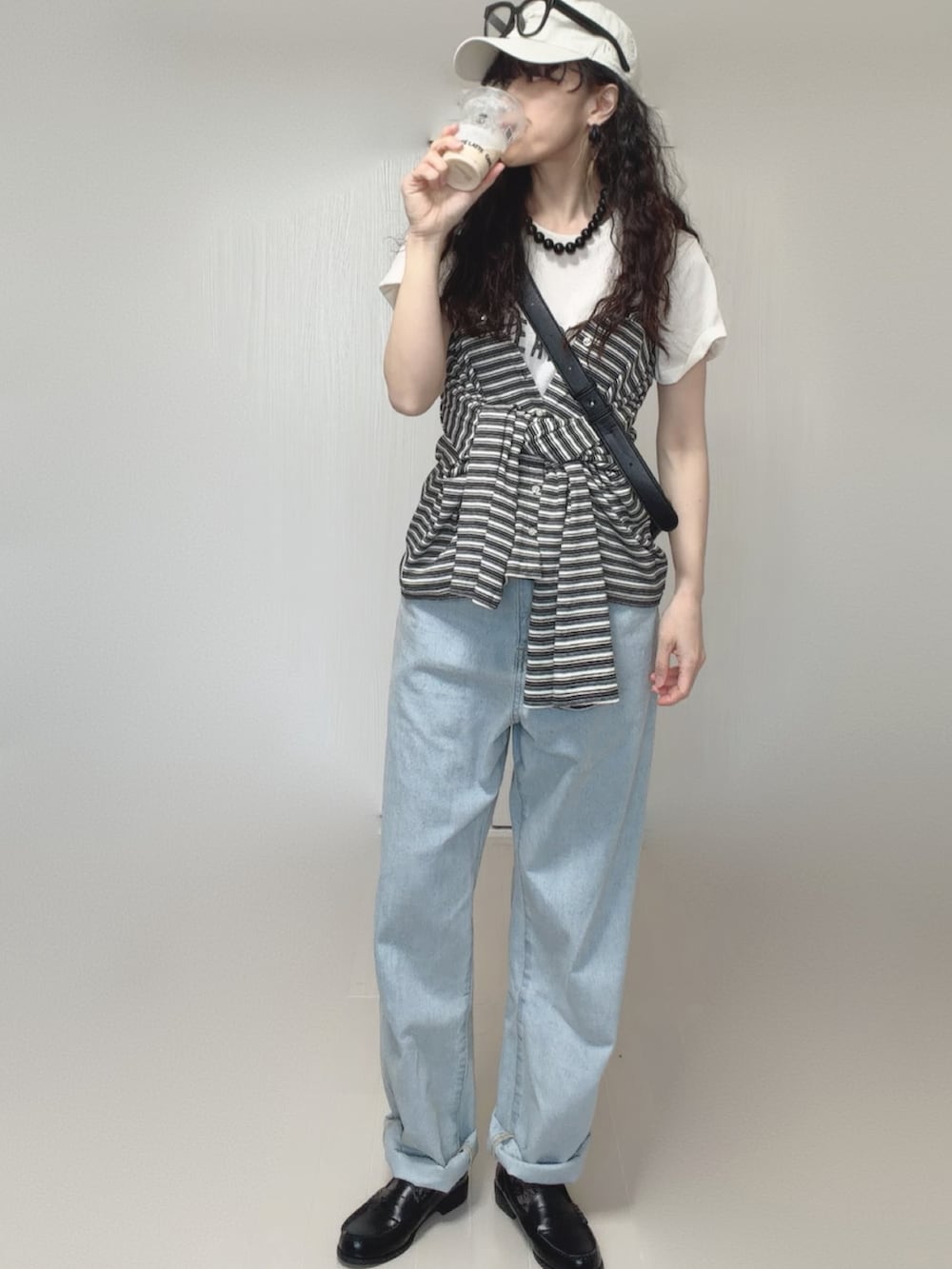 ホワイト系のTシャツ/カットソー、グレー系のカーディガン/ボレロ、ブルー系のデニムパンツを着用したレディースの春コーディネートの2枚目の写真