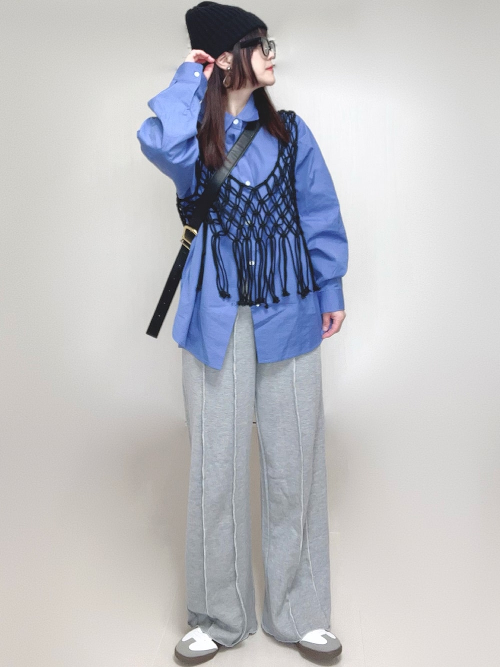 ブラック系のベスト、ブルー系のシャツ/ブラウス、グレー系のスウェットパンツを着用したレディースの春コーディネートの2枚目の写真