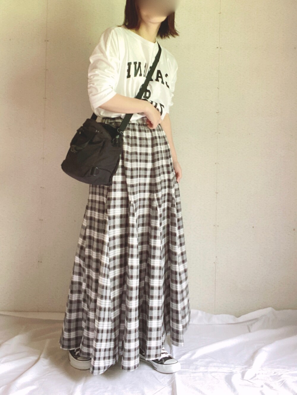 ホワイト系のTシャツ/カットソー、ブラック系のショルダーバッグ、ブラック系のスカートを着用したレディースの夏コーディネートの2枚目の写真