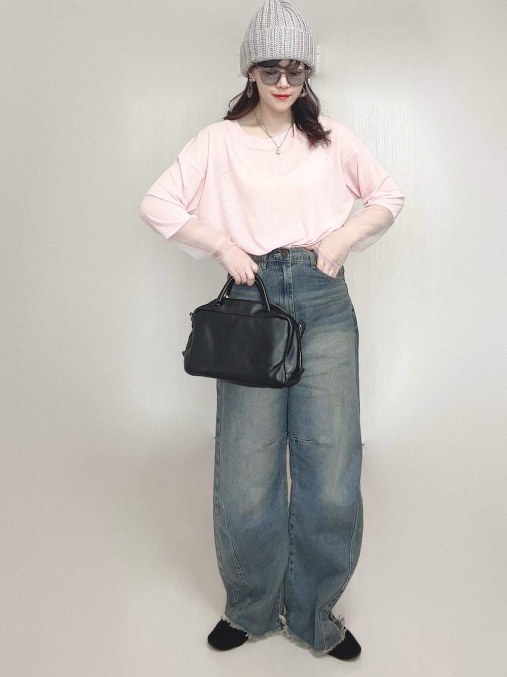 ピンク系のTシャツ/カットソー、ブルー系のデニムパンツ、ブラック系のボストンバッグを着用したレディースの春コーディネートの2枚目の写真
