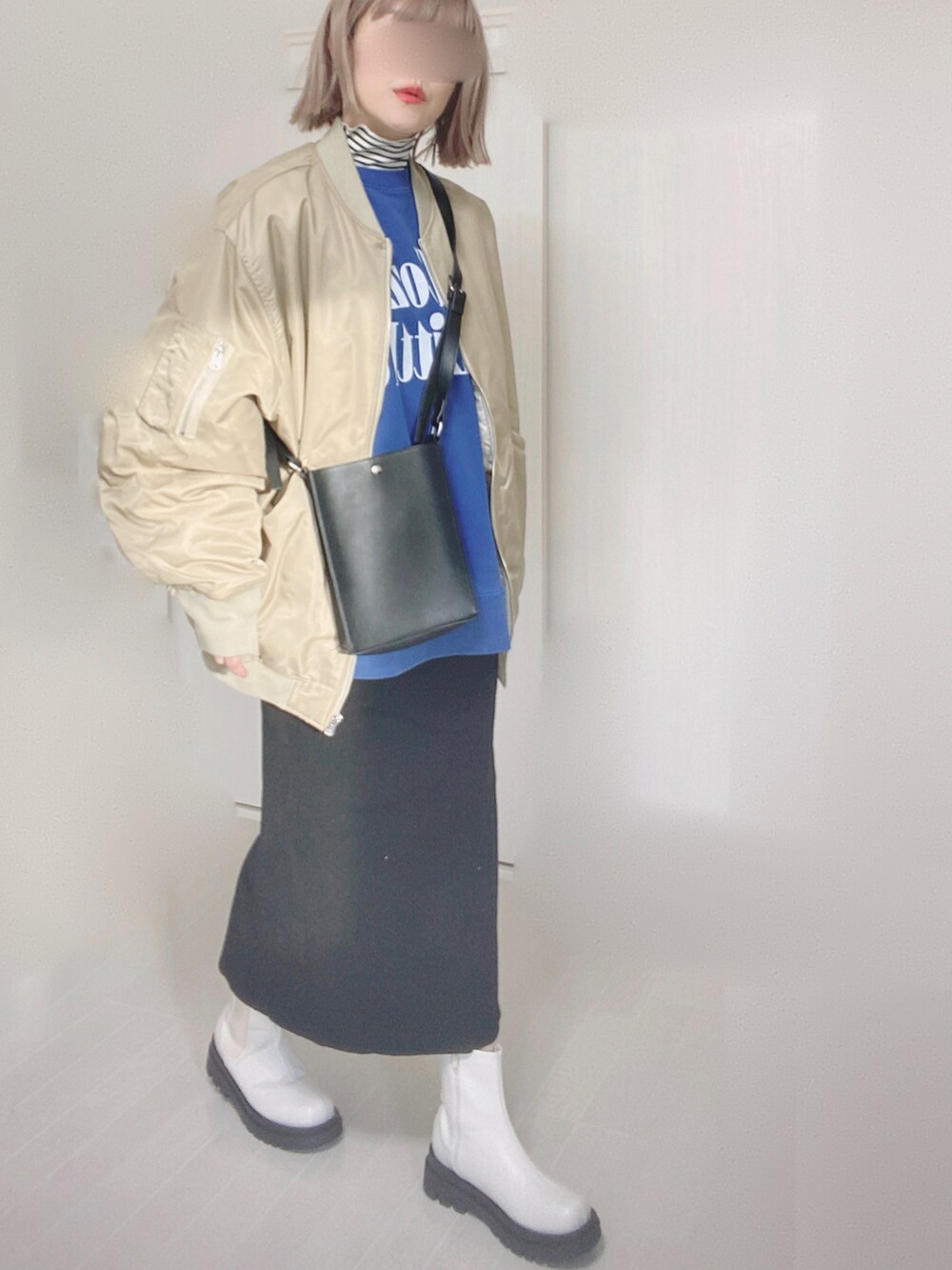 ベージュ系のMA-1、ホワイト系のTシャツ/カットソー、ブルー系のスウェットを着用したレディースの冬コーディネートの4枚目の写真