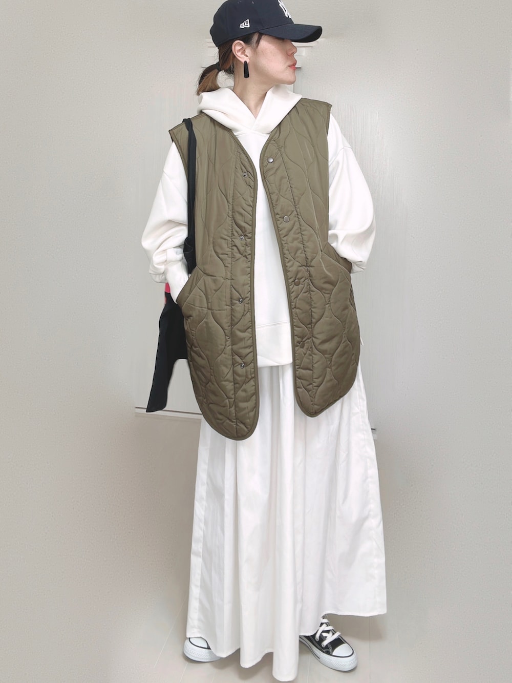 ホワイト系のパーカー、ブラック系のトートバッグ、ホワイト系のスカートを着用したレディースの秋コーディネートの5枚目の写真